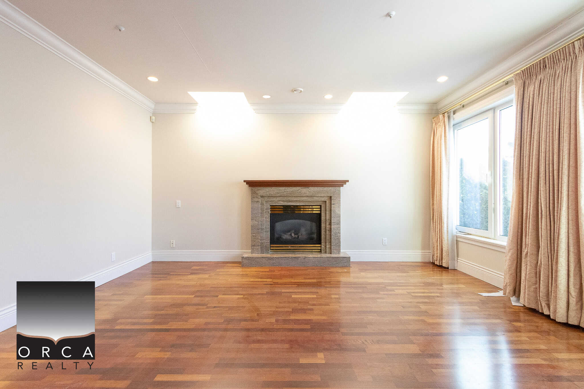 9 Spacious living room with a modern fireplace, hardwood floors, and large windows offering natural light, ideal for Vancouver real estate buyers.