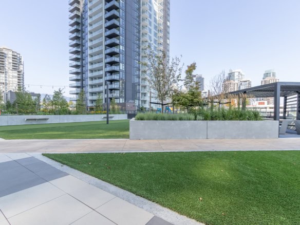 Modern urban outdoor space with landscaped greenery and high-rise residential buildings, ideal for real estate investors and homebuyers in Vancouver.