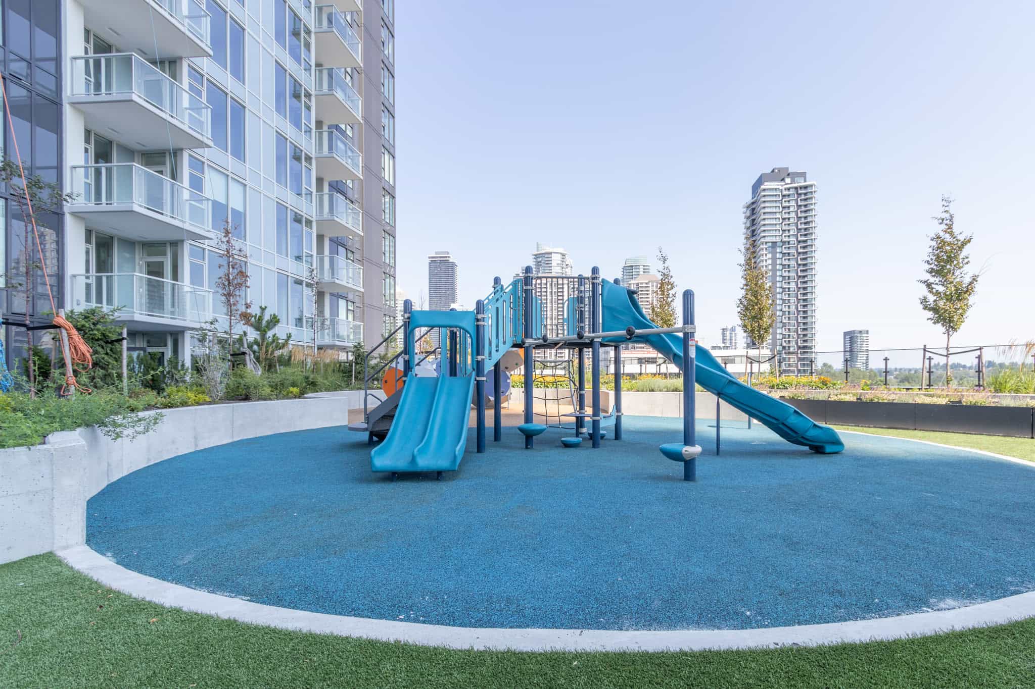 Modern urban playground with safety surfacing for families in Vancouver's condo community by Orca Realty Inc.