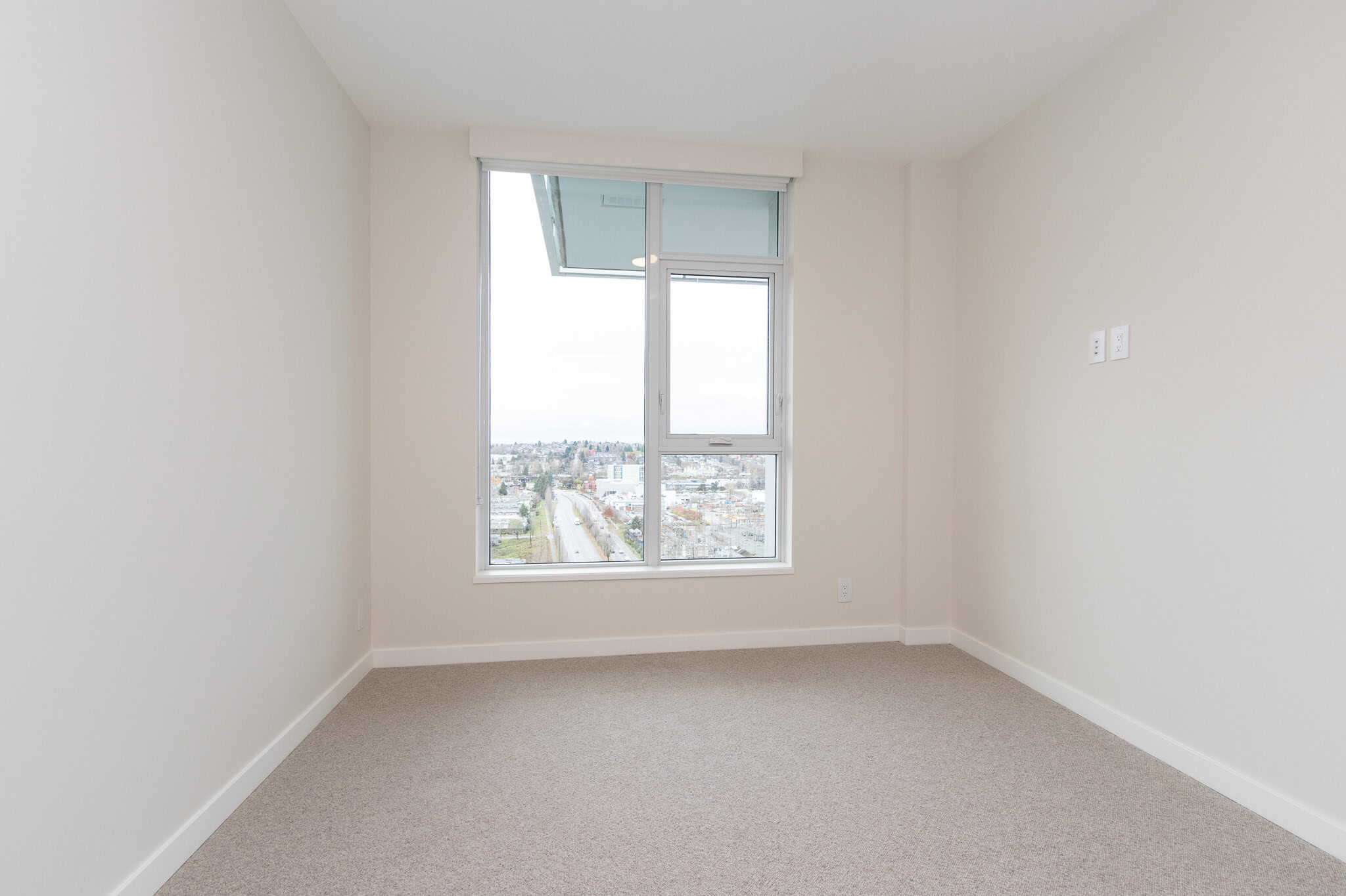 Bright modern apartment interior with large window and city view in Vancouver, BC. Perfect for real estate listings or property marketing on Orca Realty Inc. website.