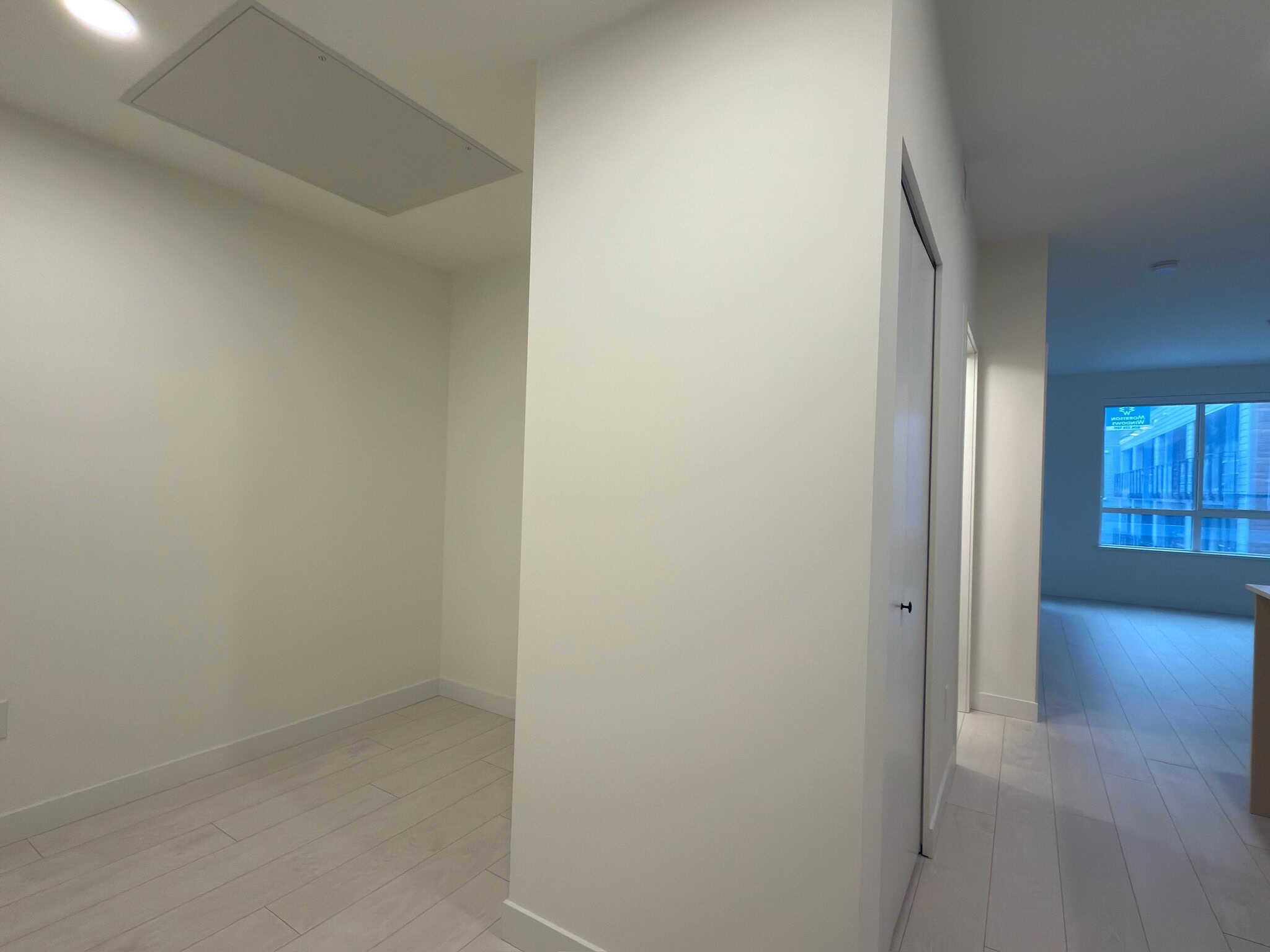 Bright modern condo interior with white walls, light wood flooring, and large windows providing ample natural light, ideal for urban living or investment properties in Vancouver.