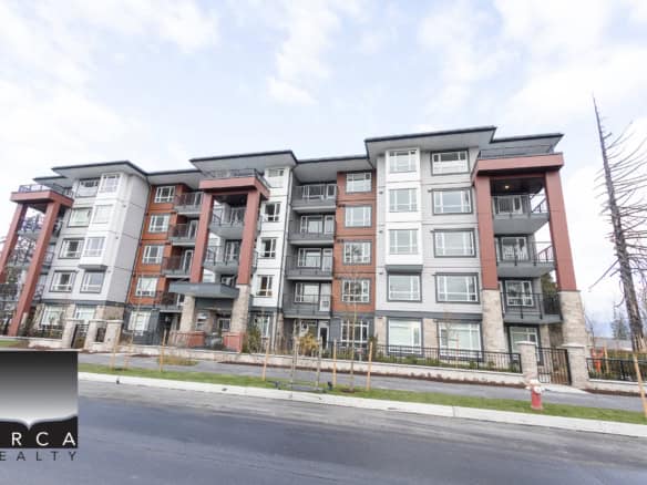 Modern multi-family residential apartment building with contemporary design, large windows, and balconies in a quiet neighbourhood.