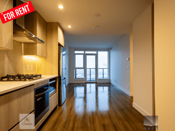 Modern open-concept kitchen with light wood cabinets and stainless steel appliances in a high-rise apartment for rent in Vancouver.