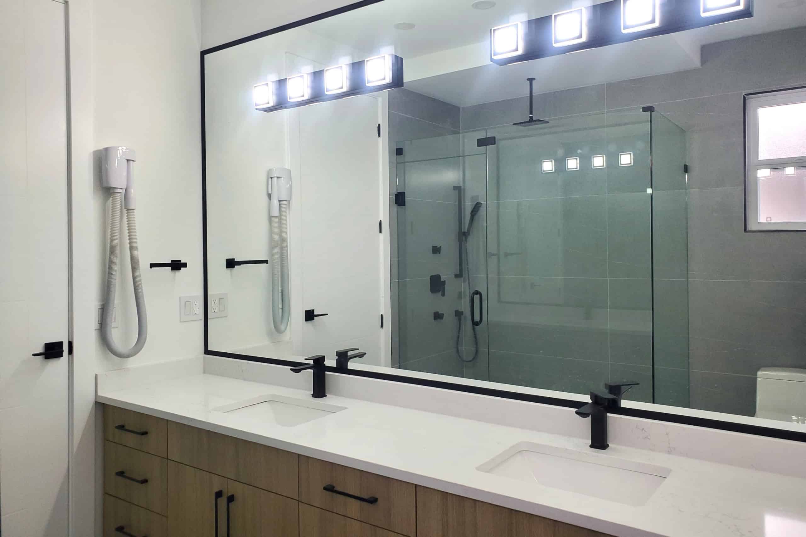 14 Modern bathroom interior with dual sinks, large mirror, and spacious glass-enclosed shower showcasing contemporary design and high-end fixtures, ideal for Vancouver Island real estate.
