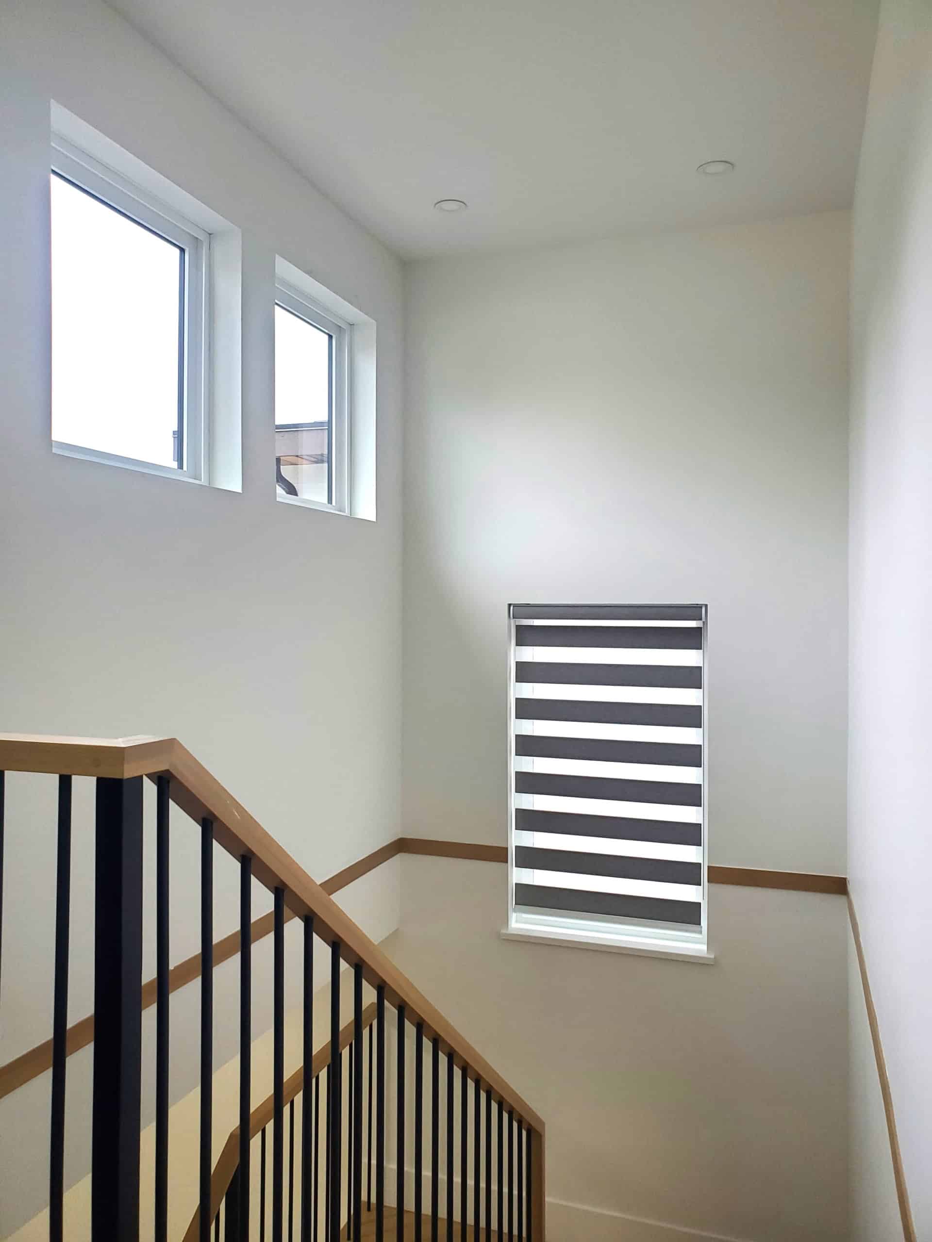 21 Bright modern interior staircase with large windows and stylish black and white window blinds, showcasing contemporary residential home design in Vancouver.