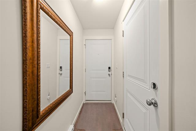 Bright modern condo entrance with white walls, large mirror, and secure door, showcasing Toronto real estate listings.