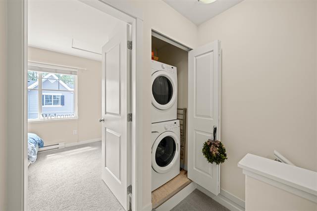 Modern laundry closet with stacked washer and dryer in a bright, clean home interior, showcasing efficient space utilization.