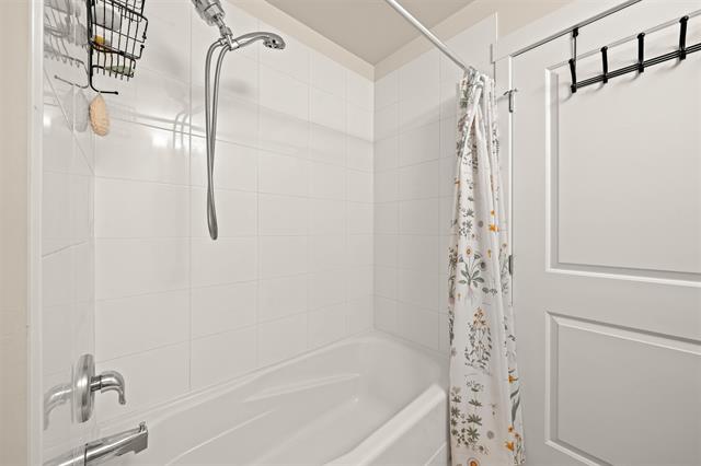 Clean white bathroom bathtub with showerhead and decorative shower curtain, ideal for modern home bathrooms in Vancouver, BC.