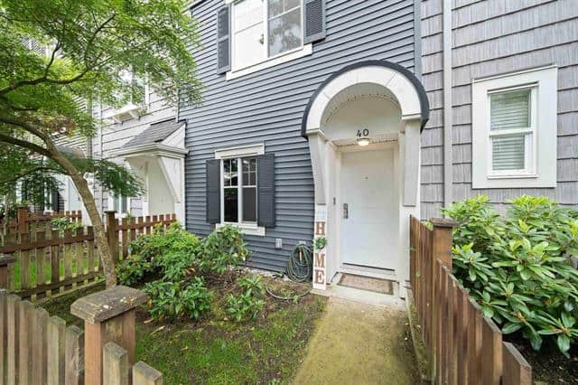 Charming residential home entrance with well-maintained garden and wooden fencing in a neighbourhood, showcasing the inviting exterior of a property listed by Orca Realty Inc.