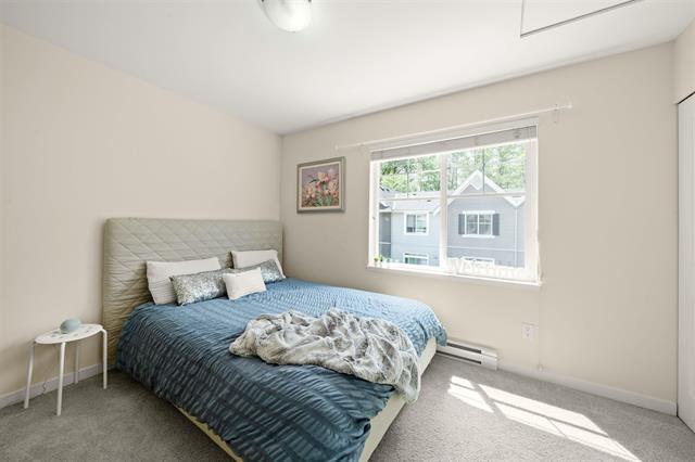 Spacious bedroom with large window, modern decor, and cozy bedding, ideal for showcasing Vancouver-area homes listed by Orca Realty Inc.