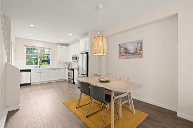 Bright, modern kitchen and dining area with white cabinetry, stainless steel appliances, and a cozy dining nook with a wooden table and stylish chairs, perfect for family meals and entertaining.