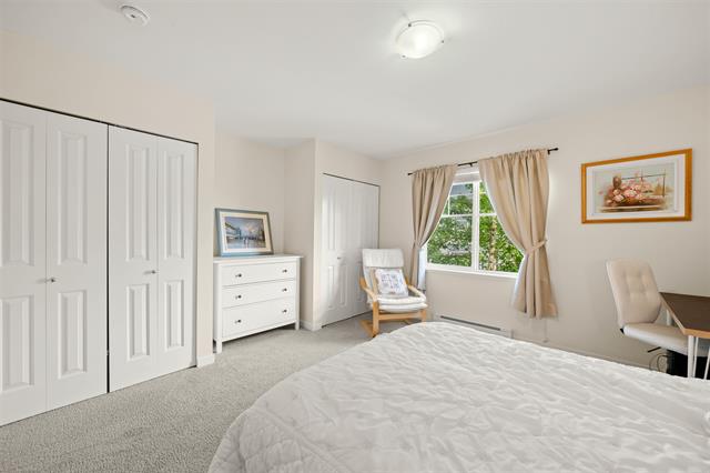 Modern bedroom interior with white walls, large window with beige curtains, and contemporary furniture for comfortable living. Perfect for buyers seeking a cozy, move-in ready home in the Vancouver area.