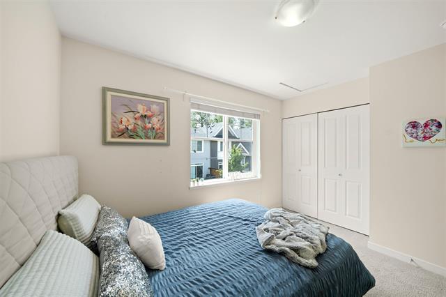 Bright bedroom with large window, neutral decor, and ample closet space, ideal for Vancouver or BC homebuyers seeking cozy, modern living spaces.
