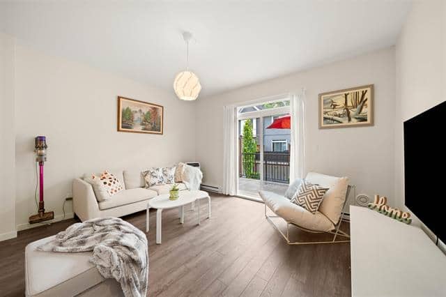 Spacious living room with modern decor, large window, neutral colours, and inviting seating area, ideal for Vancouver-area homes listed by Orca Realty Inc.