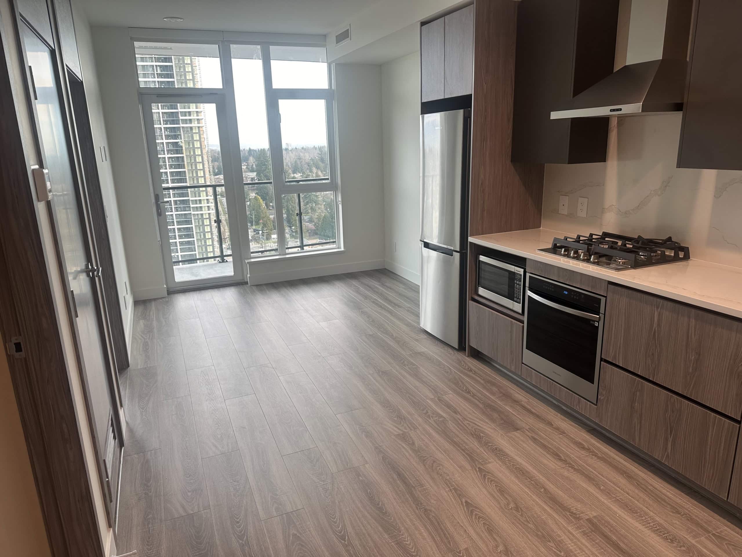 Modern Downtown Vancouver apartment kitchen with stainless steel appliances and large windows for natural light, perfect for city living.