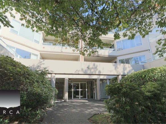 Modern apartment building entrance with lush greenery in North Vancouver, showcasing Orca Realty Inc. real estate services in a vibrant community setting.