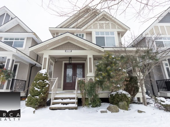 Spacious modern house exterior with snow-covered landscaping, featuring a large front porch, contemporary architectural design, and well-maintained garden, ideal for Vancouver Island real estate.