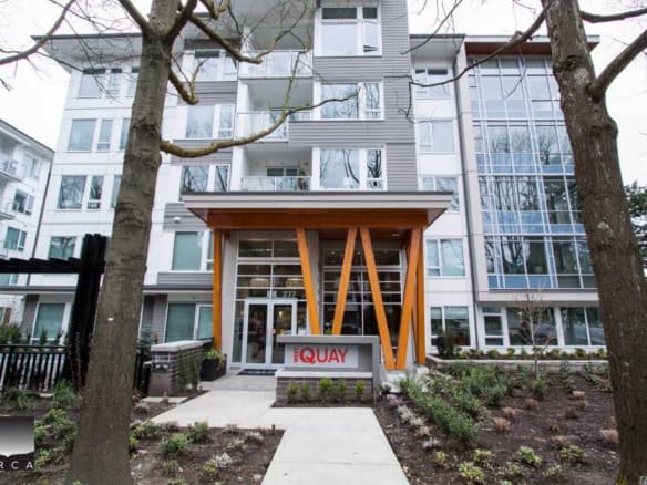 Modern downtown Vancouver apartment building with a contemporary entrance and well-maintained landscaping, showcasing Orca Realty Inc. services for real estate opportunities.