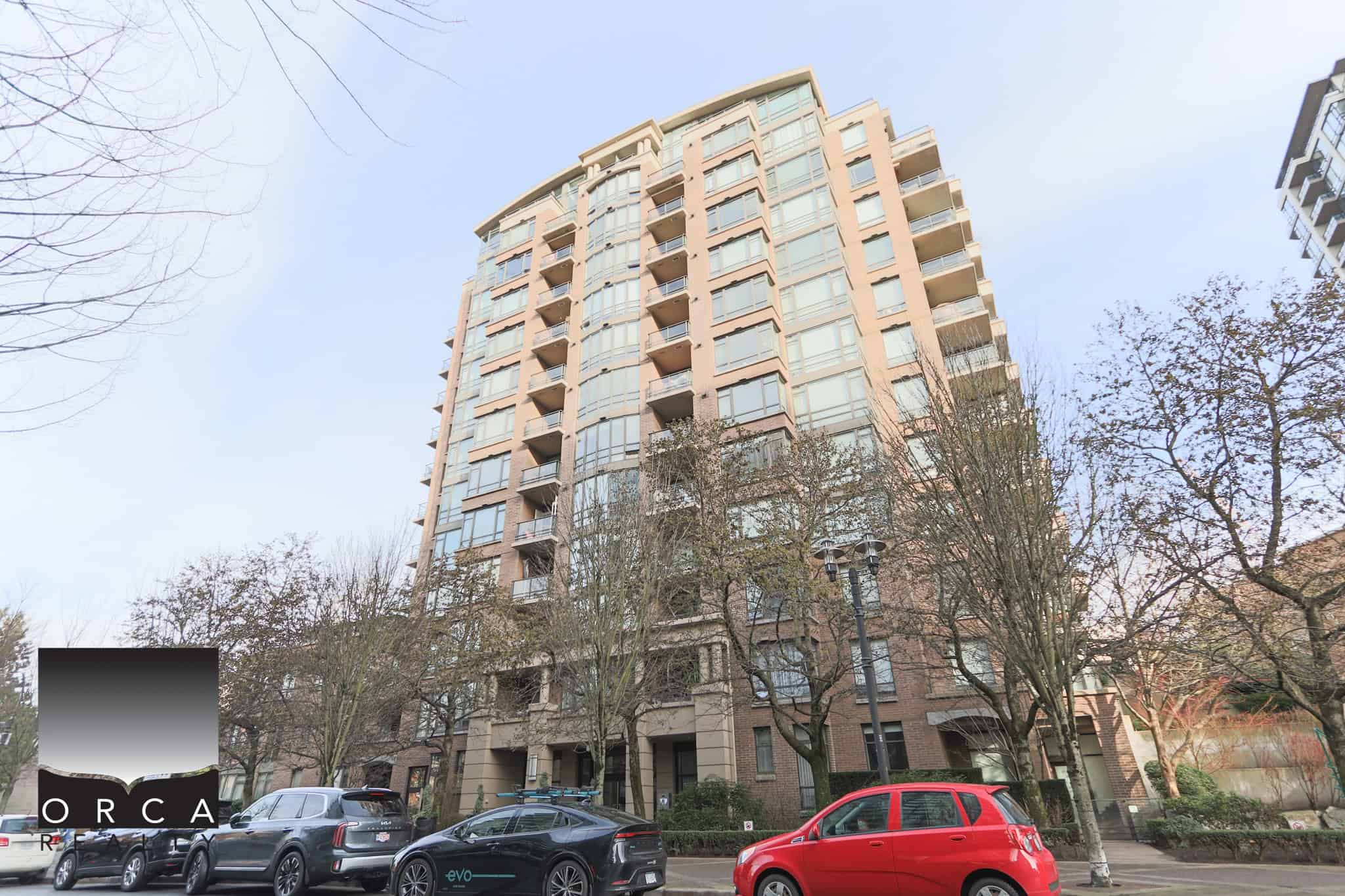 Modern North Vancouver condo building with glass balconies and urban surroundings.