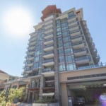 Modern high-rise condo building in Downtown Vancouver, featuring glass balconies, contemporary architecture, and luxury apartments near local amenities and public transportation.
