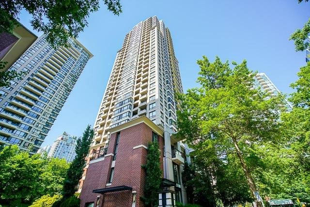 Modern high-rise condominium building in downtown Vancouver, BC, surrounded by green trees.