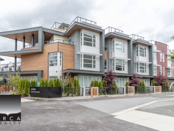Modern multi-family residential building in Vancouver, featuring contemporary design with large windows, mixed exterior materials, and landscaped surroundings, offered by Orca Realty Inc.