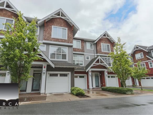 Contemporary multi-story townhouse with modern exterior design and attached garage, surrounded by lush greenery in a vibrant neighbourhood, ideal for families or investors.