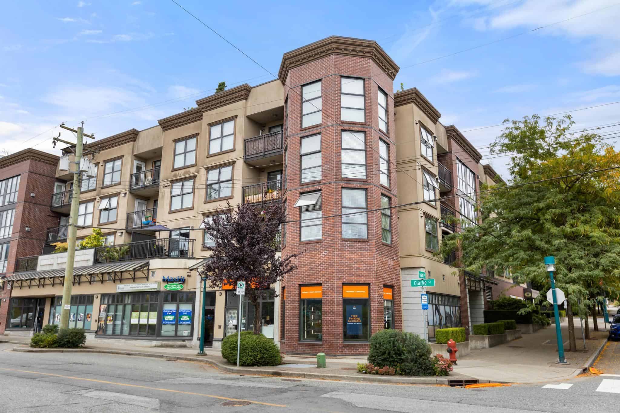 Modern multi-story residential building with retail space on the ground floor, located at a busy street corner in Vancouver. The property features balconies, large windows, and a brick facade, representing Vancouver's urban apartment living.