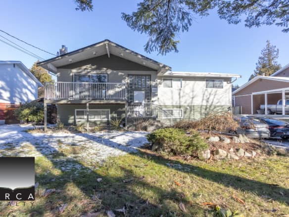 Modern residential home showcasing prime real estate in Victoria, BC, with a spacious front yard, ample parking, and contemporary design elements; perfect for families and investors seeking a comfortable living space.