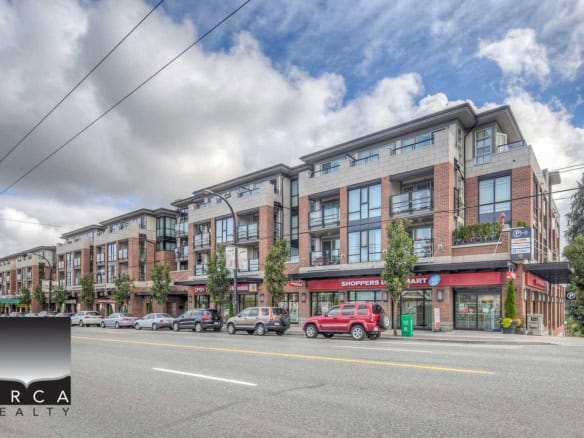 Modern mixed-use apartment building with retail stores on the ground floor, located in a busy urban area with parking and storefronts.