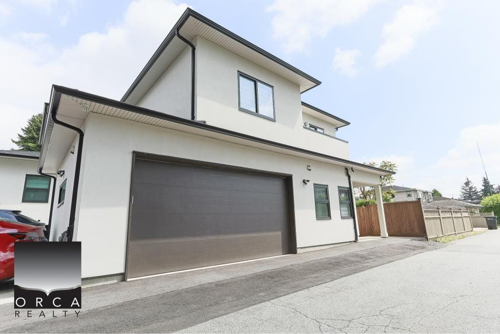 Modern white two-storey duplex with attached garage and black accents, located in a residential area. Ideal for homebuyers seeking contemporary architecture and spacious living in Ontario.