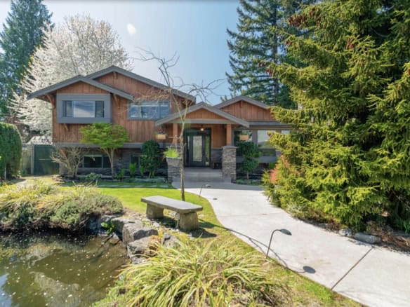 Modern Vancouver-style house with lush landscaped garden and pond, ideal for Vancouver real estate buyers.