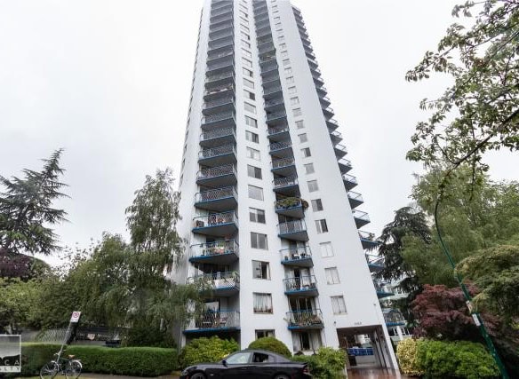Modern high-rise condominium building with multiple balconies in a lush urban setting in Vancouver, BC.
