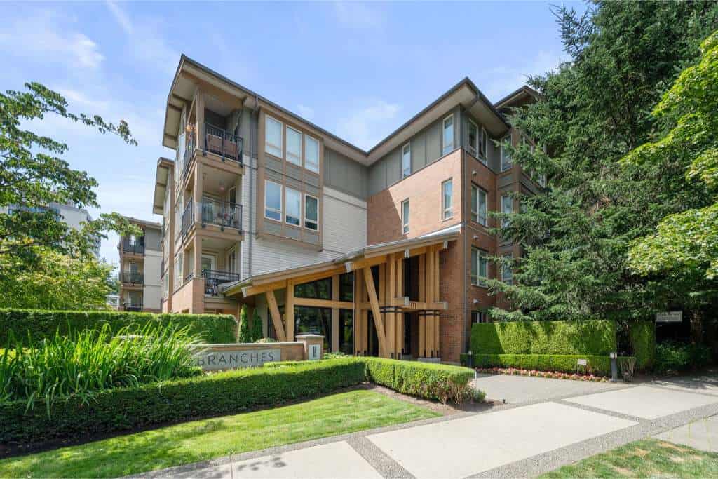 Modern multi-family residential building with landscaped gardens and contemporary architectural design in Vancouver.