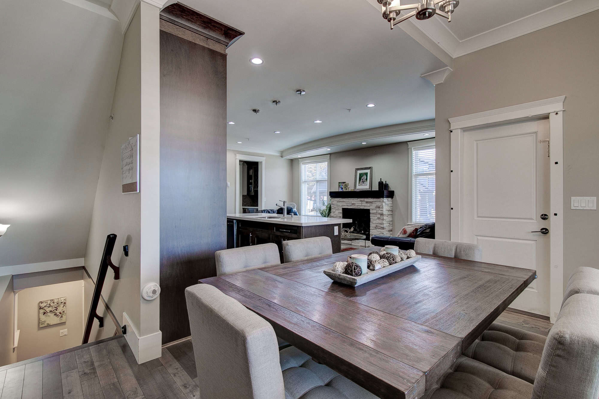 Spacious dining area in a modern home, featuring a large wooden table, neutral-toned chairs, and stylish decor, perfect for family gatherings and entertaining guests.