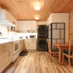 Cozy Vancouver Island kitchen with modern appliances, wood accents, and efficient laundry area, ideal for seamless real estate experiences in BC's scenic properties.