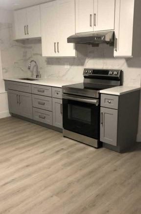 Modern fully equipped kitchen with white cabinetry and stainless steel appliances, ideal for contemporary home living.