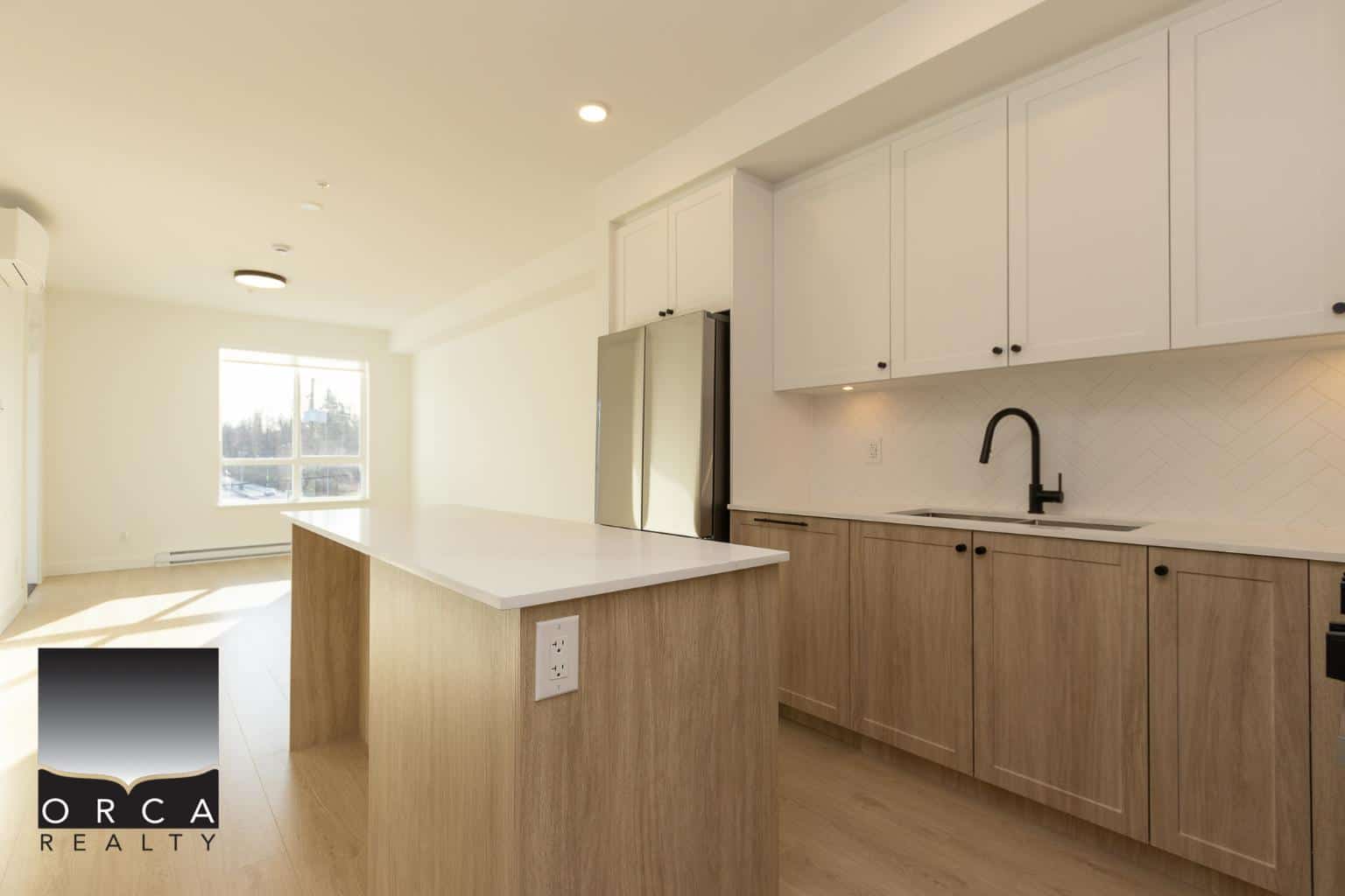 Modern minimalist kitchen with white cabinets, black faucet, and stainless steel appliances in a bright open-concept living space.