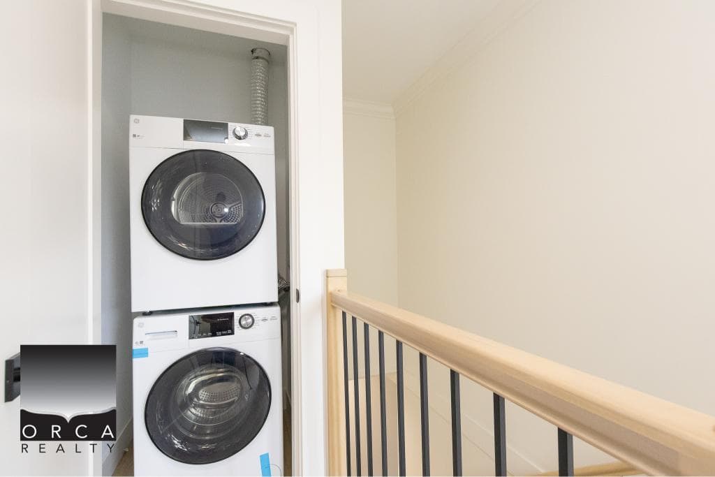Stacked washer and dryer in laundry closet, modern home appliance, convenient laundry area, residential property, home cleaning, Orca Realty Inc.