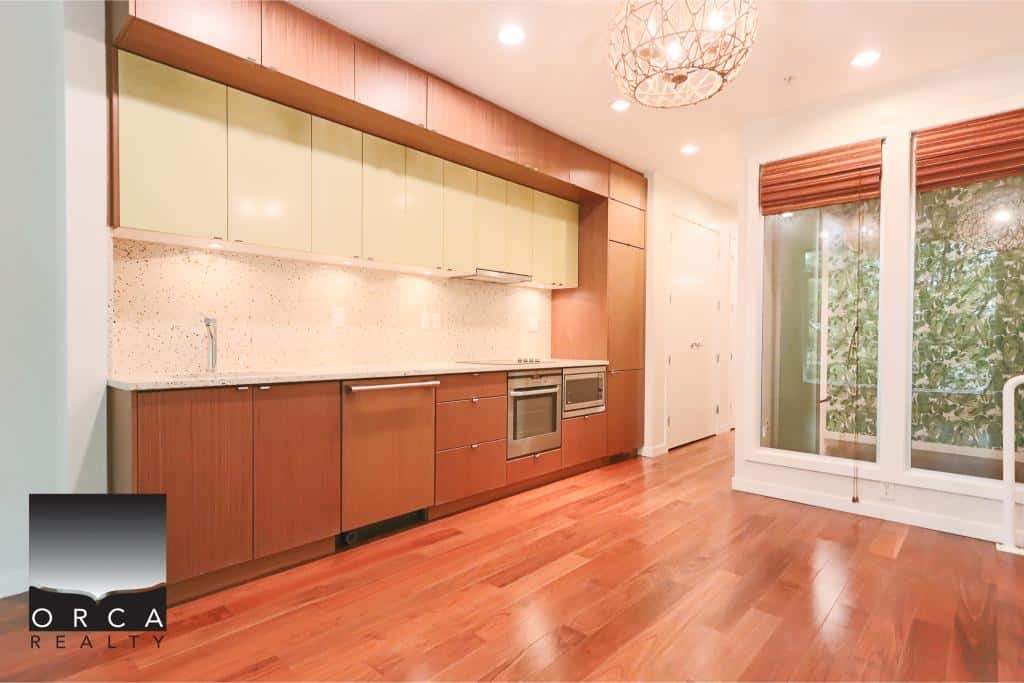 Stunning modern kitchen with hardwood floors, spacious cabinetry, stainless steel appliances, and large windows offering natural light, perfect for Vancouver real estate listings.