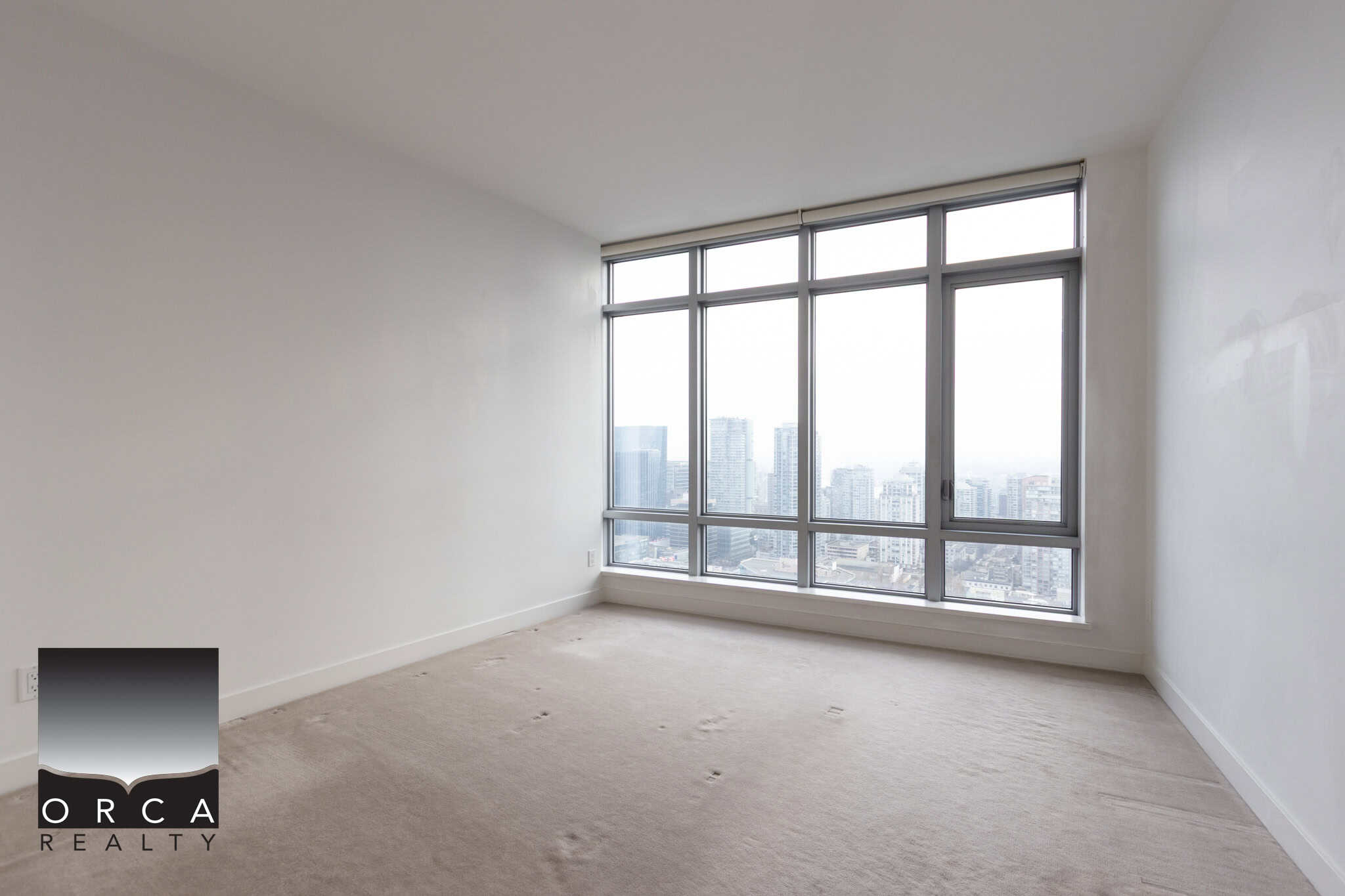 Bright modern high-rise apartment with floor-to-ceiling windows offering stunning city skyline views, spacious interior, ideal for Toronto urban living.