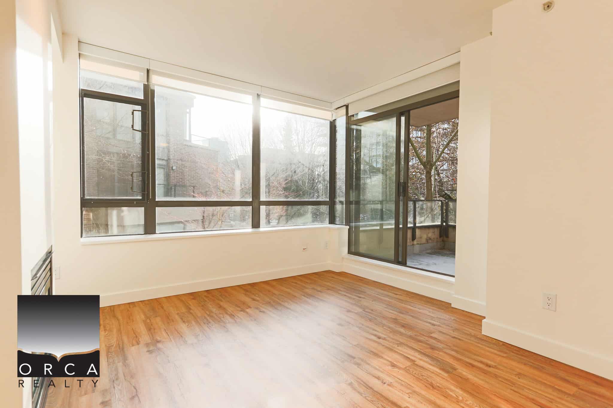 Bright, spacious living area with large windows in North Vancouver property.