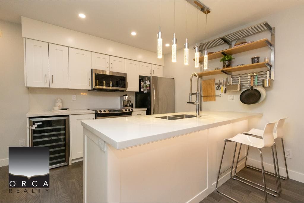 Bright modern kitchen with sleek white cabinetry, stainless steel appliances, and stylish open shelving, perfect for homebuyers seeking contemporary interior design in Vancouver.