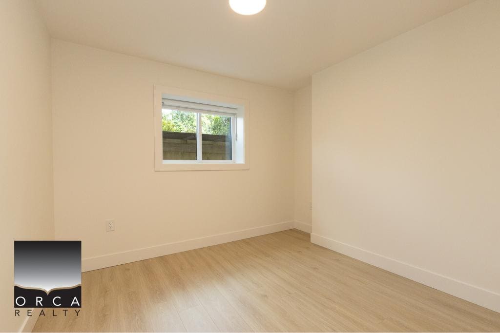 Bright empty bedroom with natural light, clean white walls, and light wood flooring, ideal for Vancouver real estate buyers seeking a modern and minimalistic home look.
