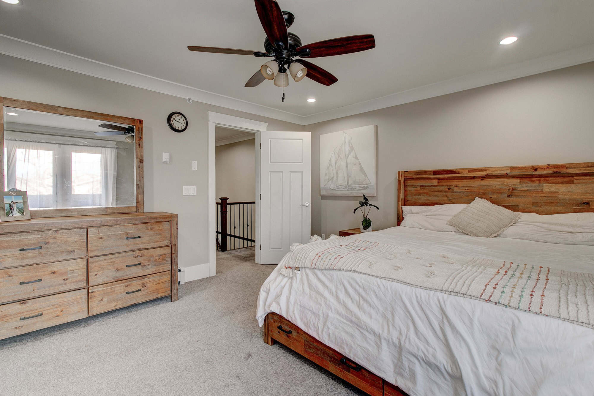 Warm neutral-toned bedroom interior with wooden furniture and modern decor, part of Orca Realty Inc.'s property listings showcasing luxurious homes in Canada.