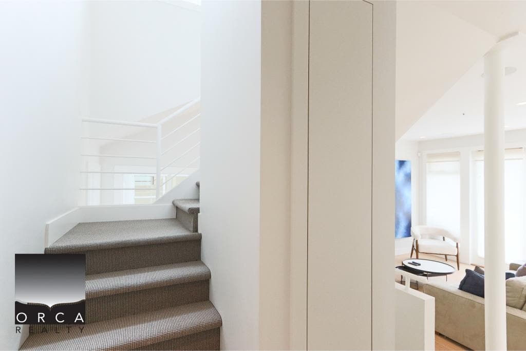 Bright modern interior of a Vancouver home, showcasing stylish stairway and cozy living room with natural light, perfect for Vancouver real estate listings and homebuyers.