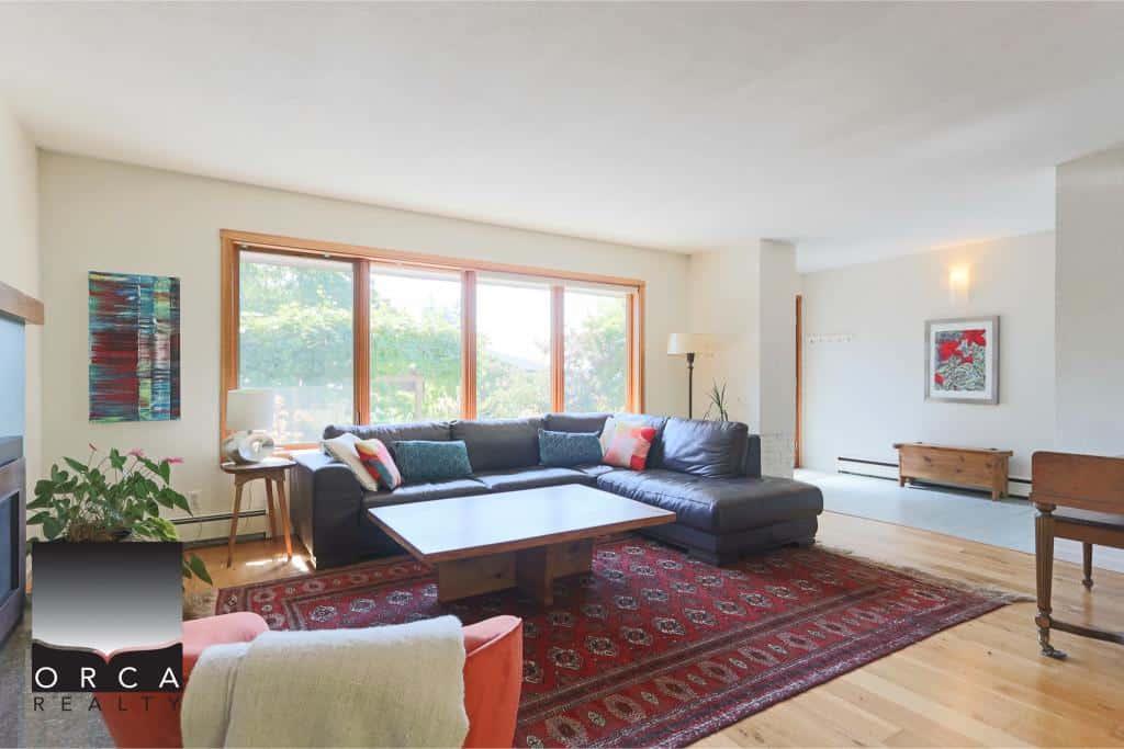 Spacious living room with large windows, modern furnishings, and a cozy atmosphere, ideal for Vancouver real estate properties and home staging.