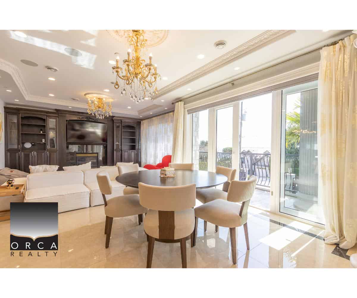 Luxurious living room with elegant chandeliers, large windows offering natural light, and stylish furniture, ideal for Vancouver real estate and properties listed by Orca Realty Inc.