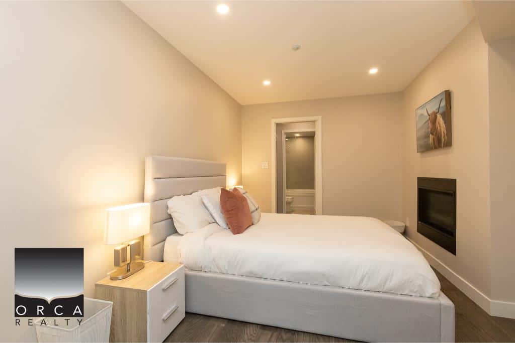 Cozy modern bedroom with neutral tones, plush bedding, and contemporary decor, perfect for relaxing in Vancouver’s real estate market.