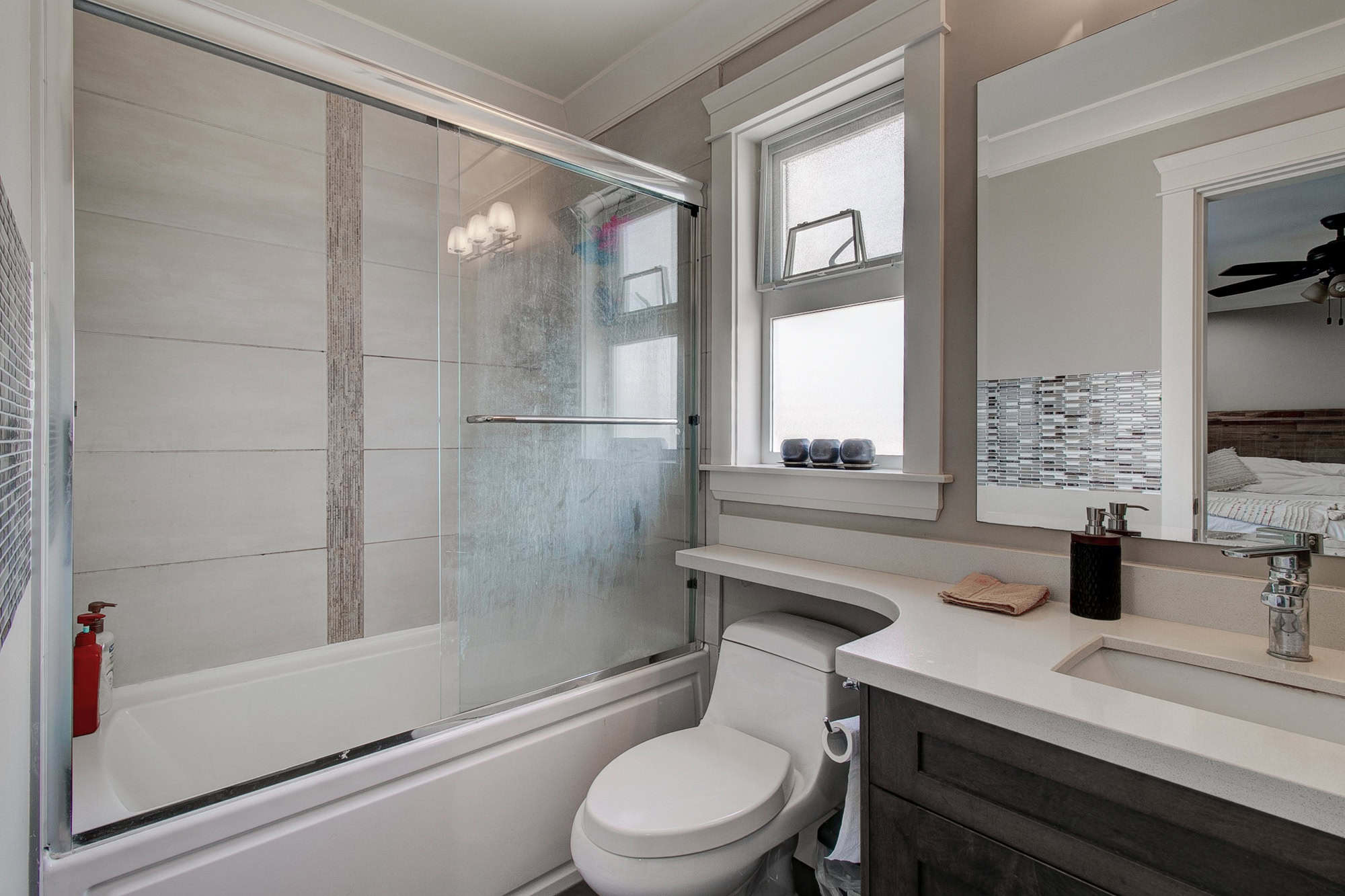 Bright modern bathroom with walk-in shower, frosted windows, and stylish vanity, showcased by Orca Realty Inc., offering professional real estate services in BC, Canada.